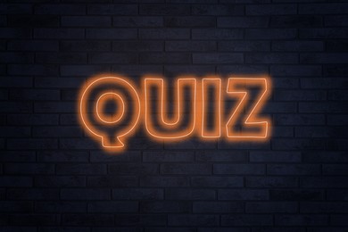 Image of Word QUIZ made of neon letters on black brick background