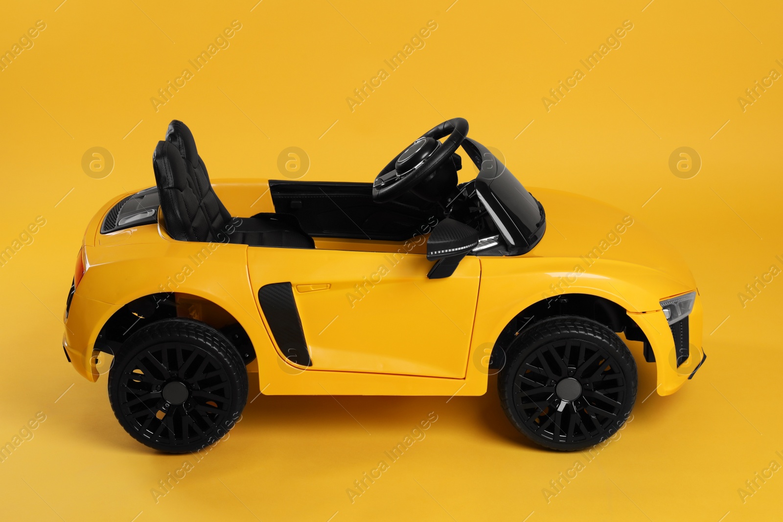 Photo of Child's electric toy car on yellow background