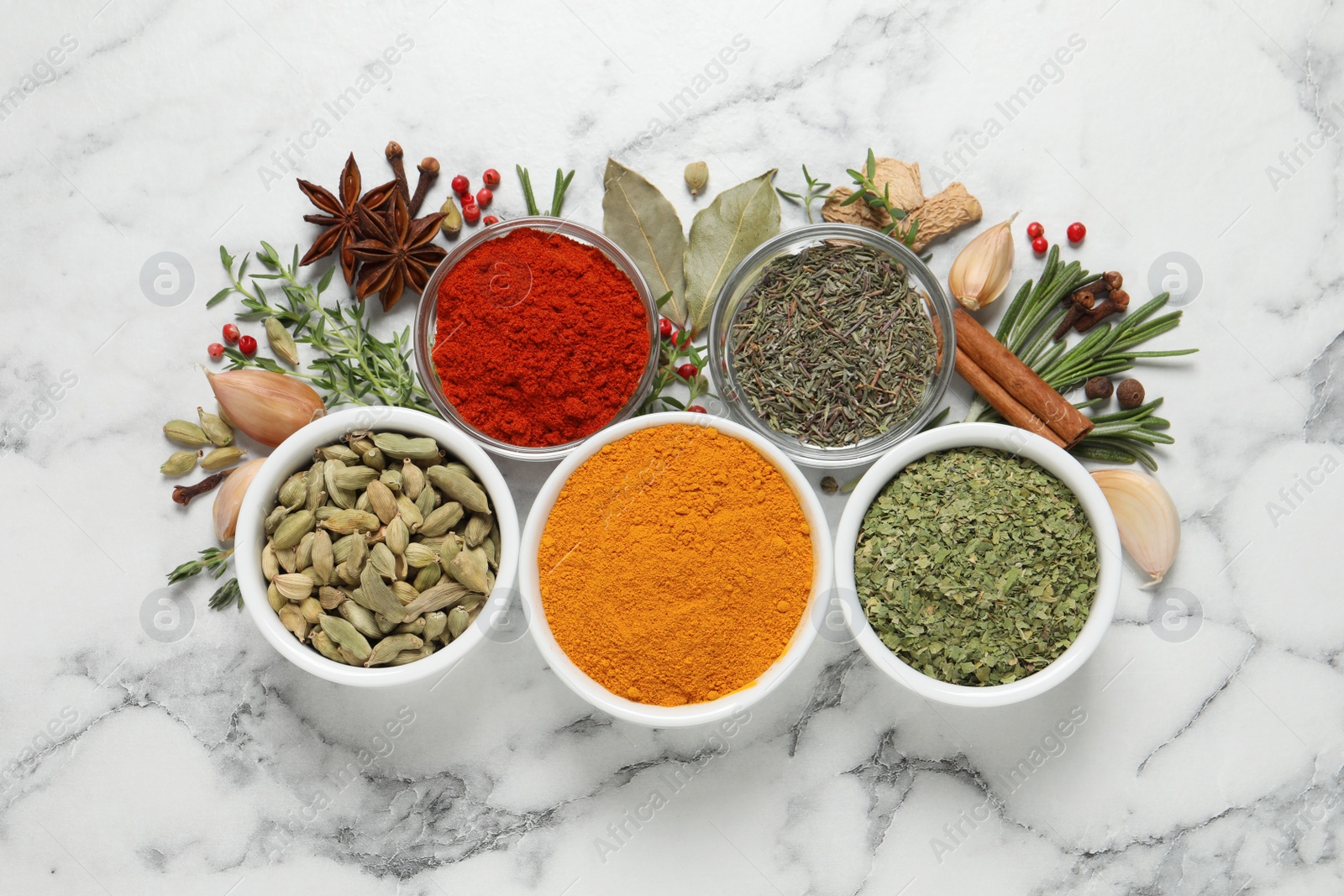 Photo of Flat lay composition with different natural spices and herbs on white marble table