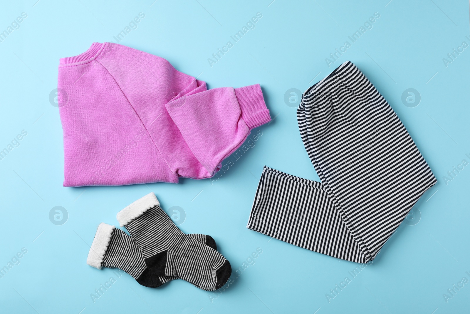 Photo of Flat lay composition with cute child clothes on color background