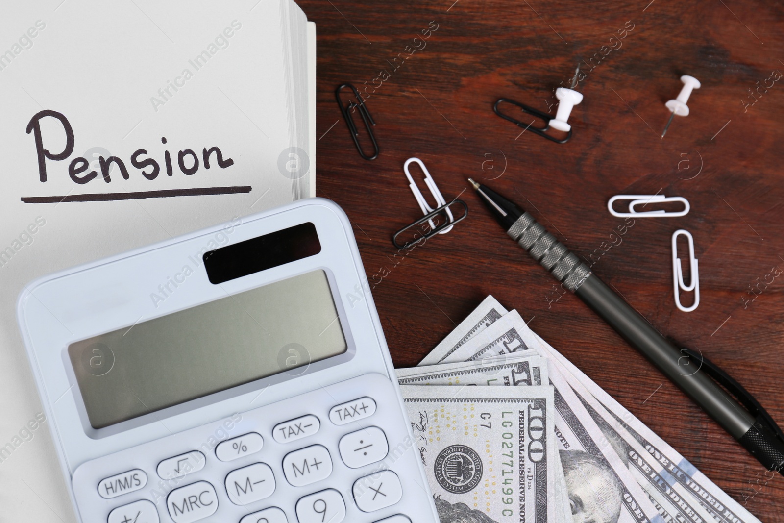 Photo of Calculator, notebook with word Pension, pen, dollar banknotes and paper clips on wooden table, flat lay. Retirement concept