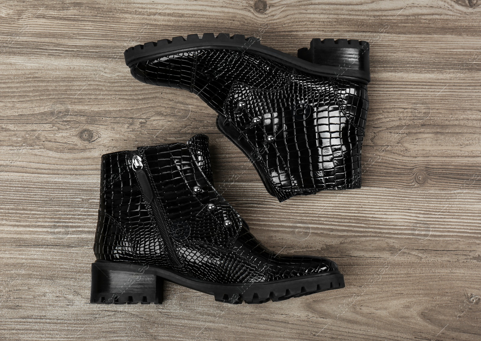 Photo of Pair of stylish ankle boots on wooden background, top view