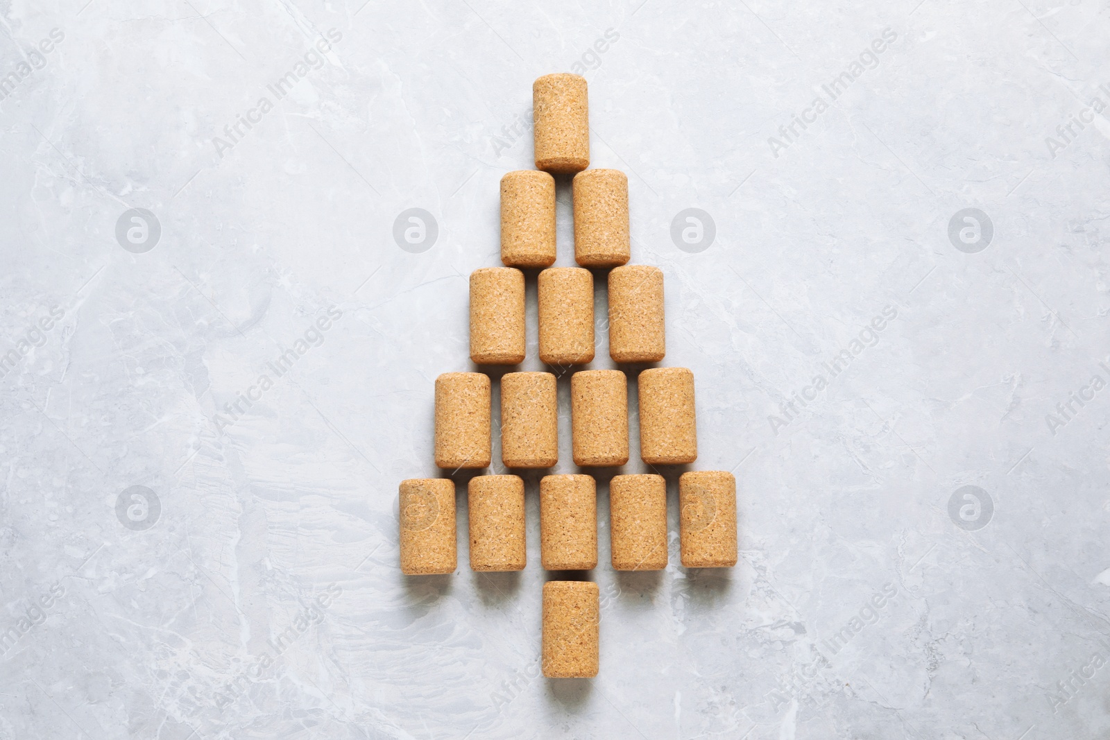 Photo of Christmas tree made of wine corks on light grey table, top view