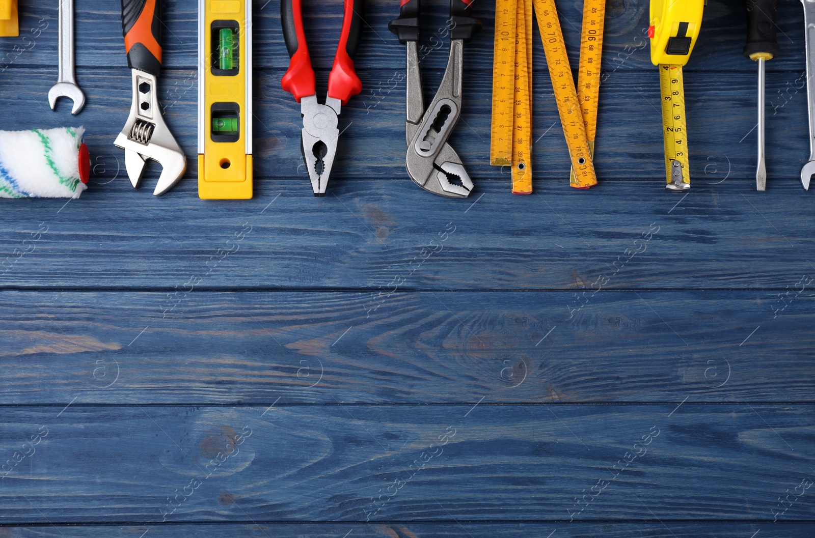 Photo of Flat lay composition with different construction tools on blue wooden background. Space for text