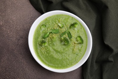 Delicious broccoli cream soup on grey table, top view