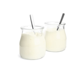 Photo of Tasty organic yogurt in glass jars with spoons isolated on white