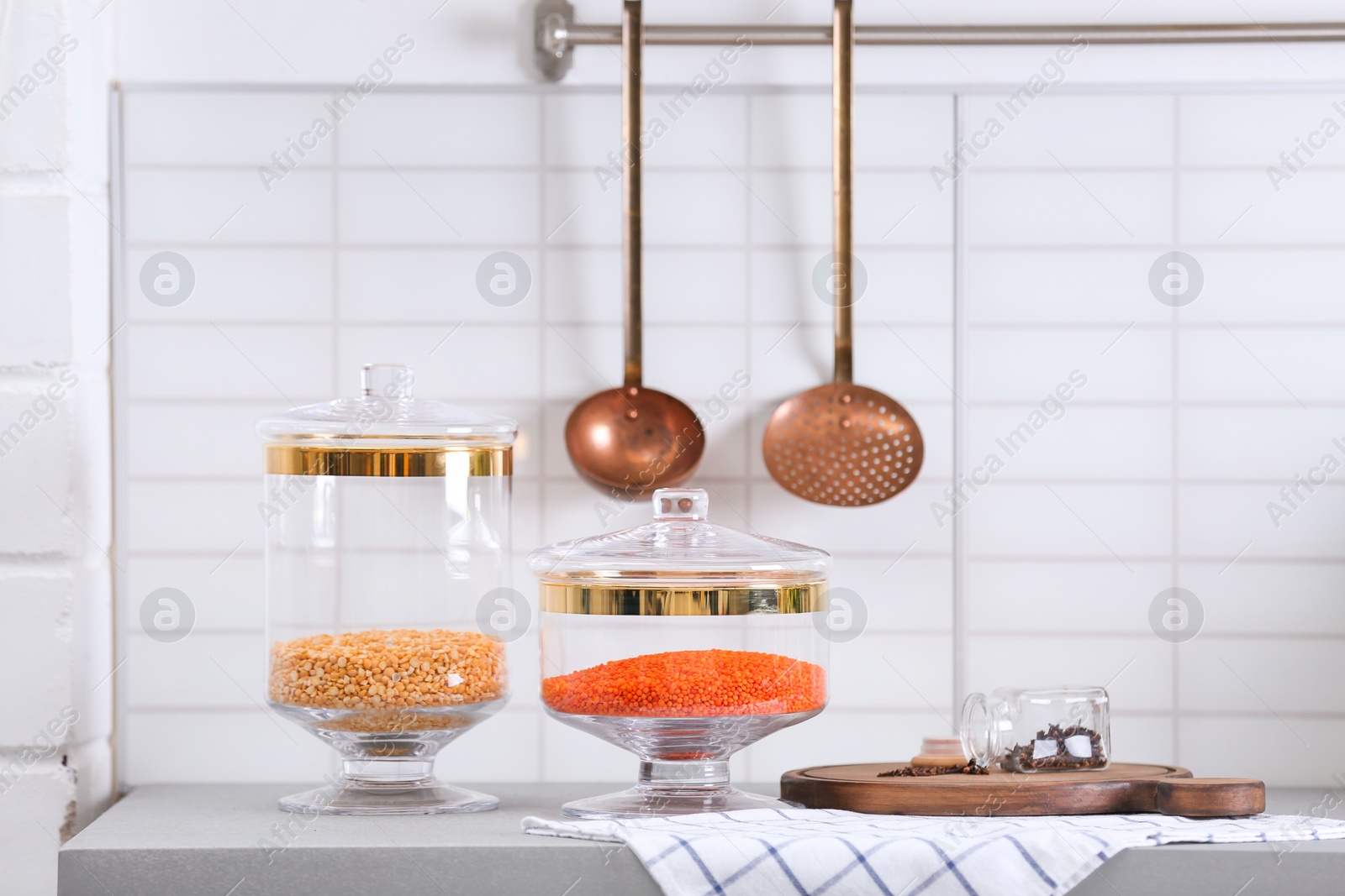 Photo of Jars with cereals on light grey table in modern kitchen