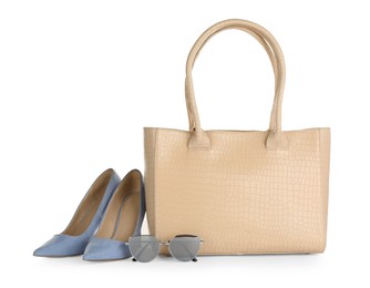 Photo of Beige women's leather bag, sunglasses and high heeled shoes on white background