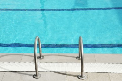 Photo of Ladder with handrails in outdoor swimming pool