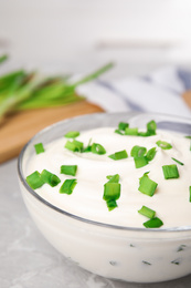 Fresh sour cream with onion in glass bowl, closeup