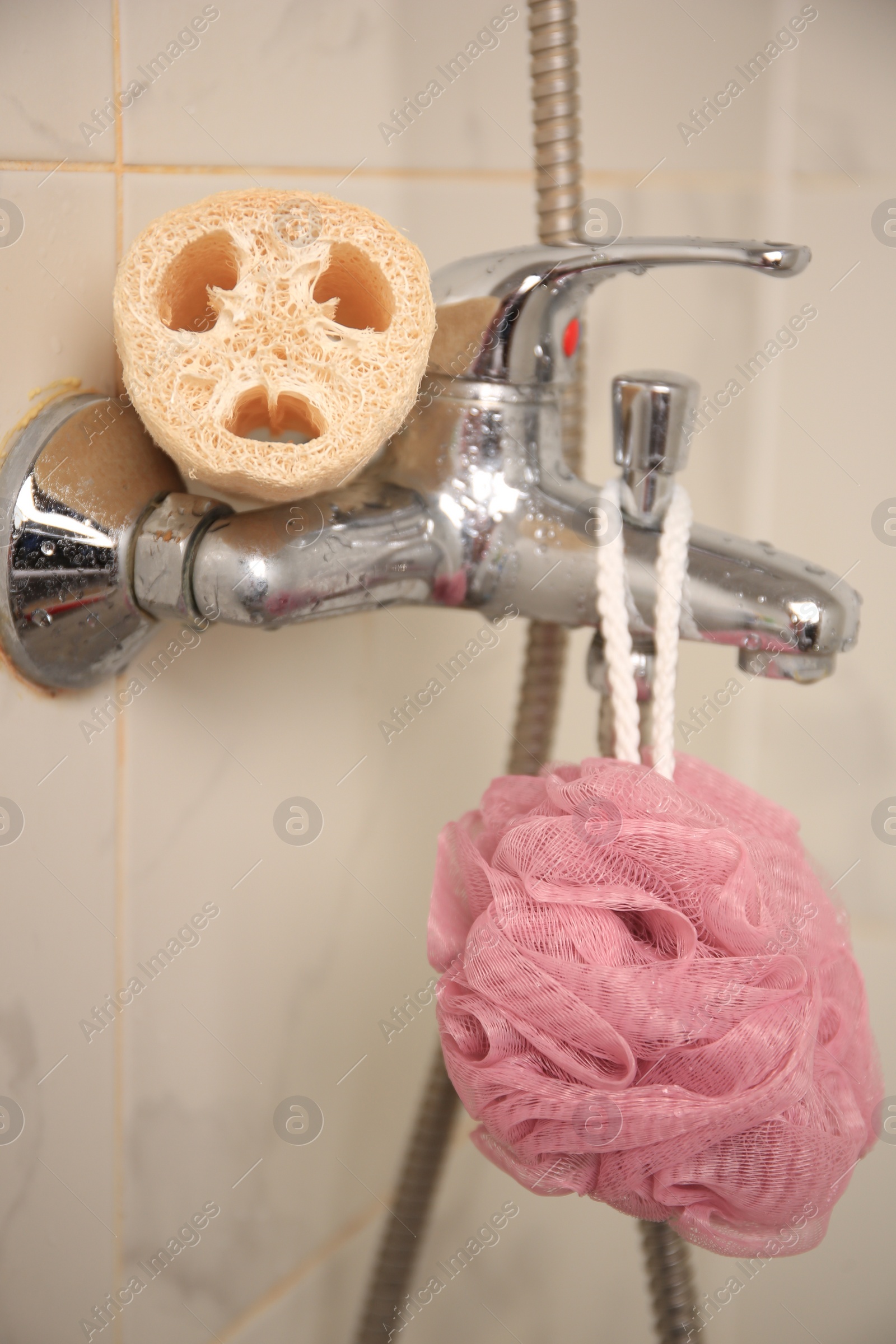 Photo of Different types of sponges on faucet in bathroom