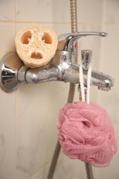 Photo of Different types of sponges on faucet in bathroom