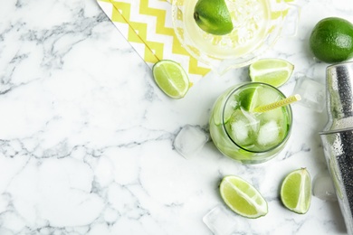 Delicious mojito and ingredients on white marble table, flat lay. Space for text