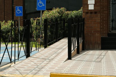 Tiled ramp with black metal railings outdoors