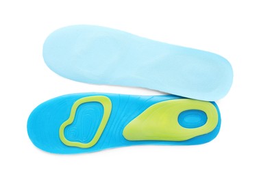 Photo of Light blue orthopedic insoles isolated on white, top view