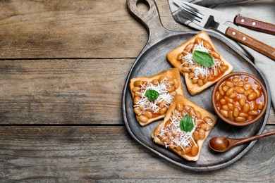 Photo of Toasts with delicious canned beans on wooden table, flat lay. Space for text