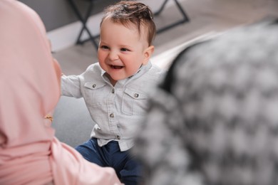 Photo of Happy Muslim family with little son at home