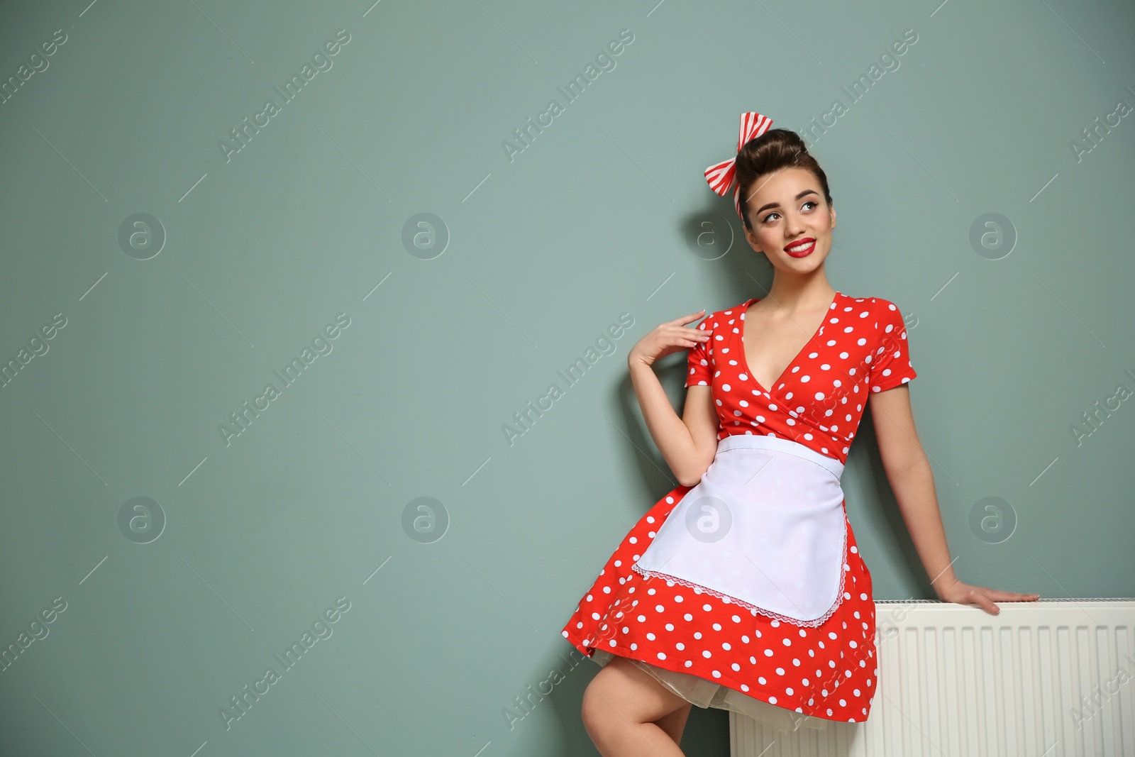 Photo of Funny young housewife near color wall