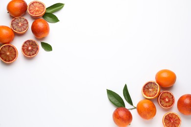 Photo of Many ripe sicilian oranges and leaves on white background, flat lay. Space for text