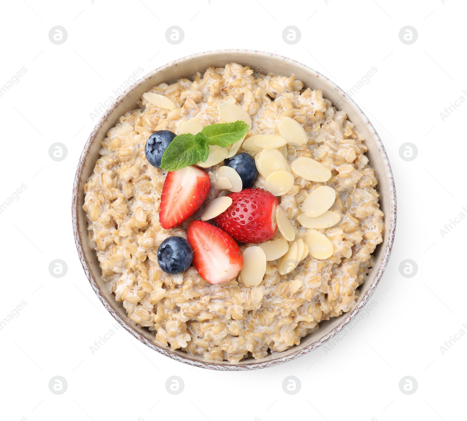 Photo of Tasty oatmeal with strawberries, blueberries and almond flakes in bowl isolated on white, top view