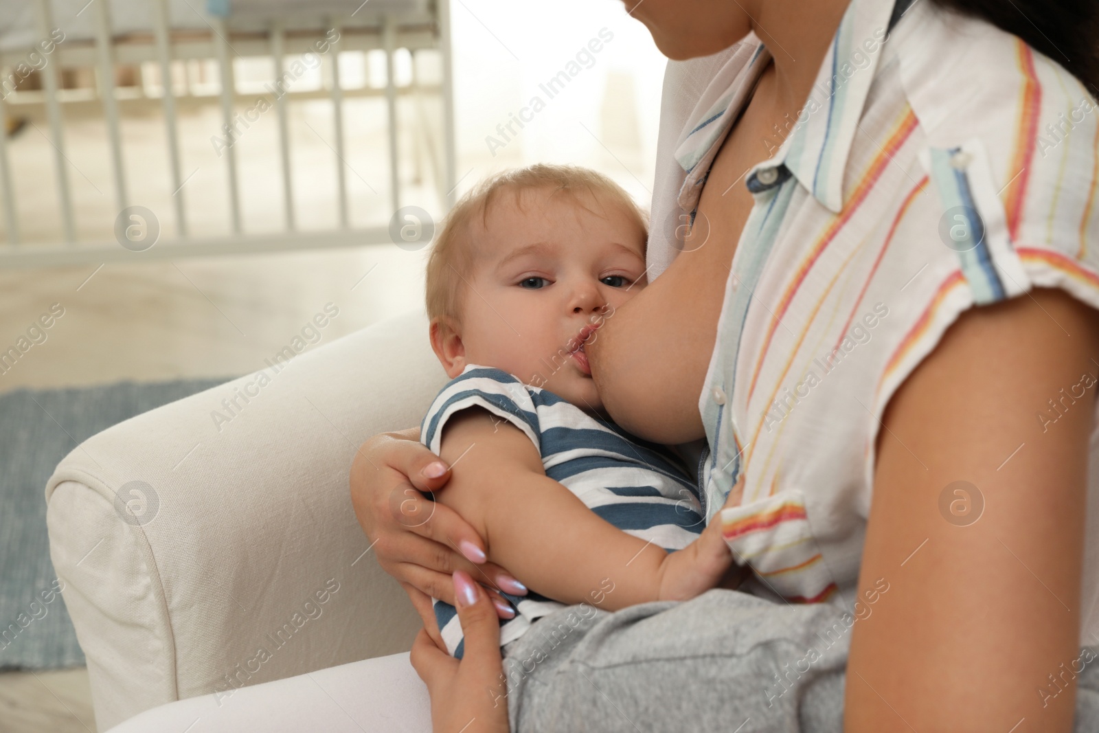 Photo of Woman breastfeeding her little baby at home