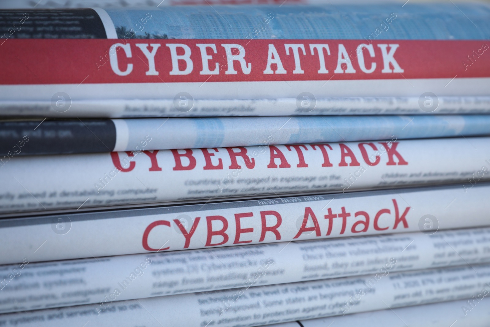 Photo of Stacked newspapers with headlines CYBER ATTACK as background, closeup