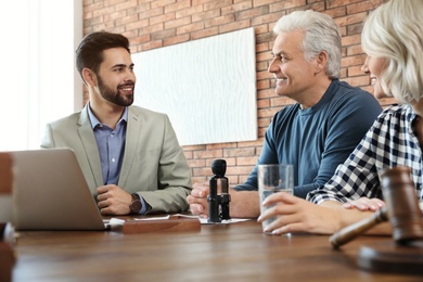 Male notary working with mature couple in office