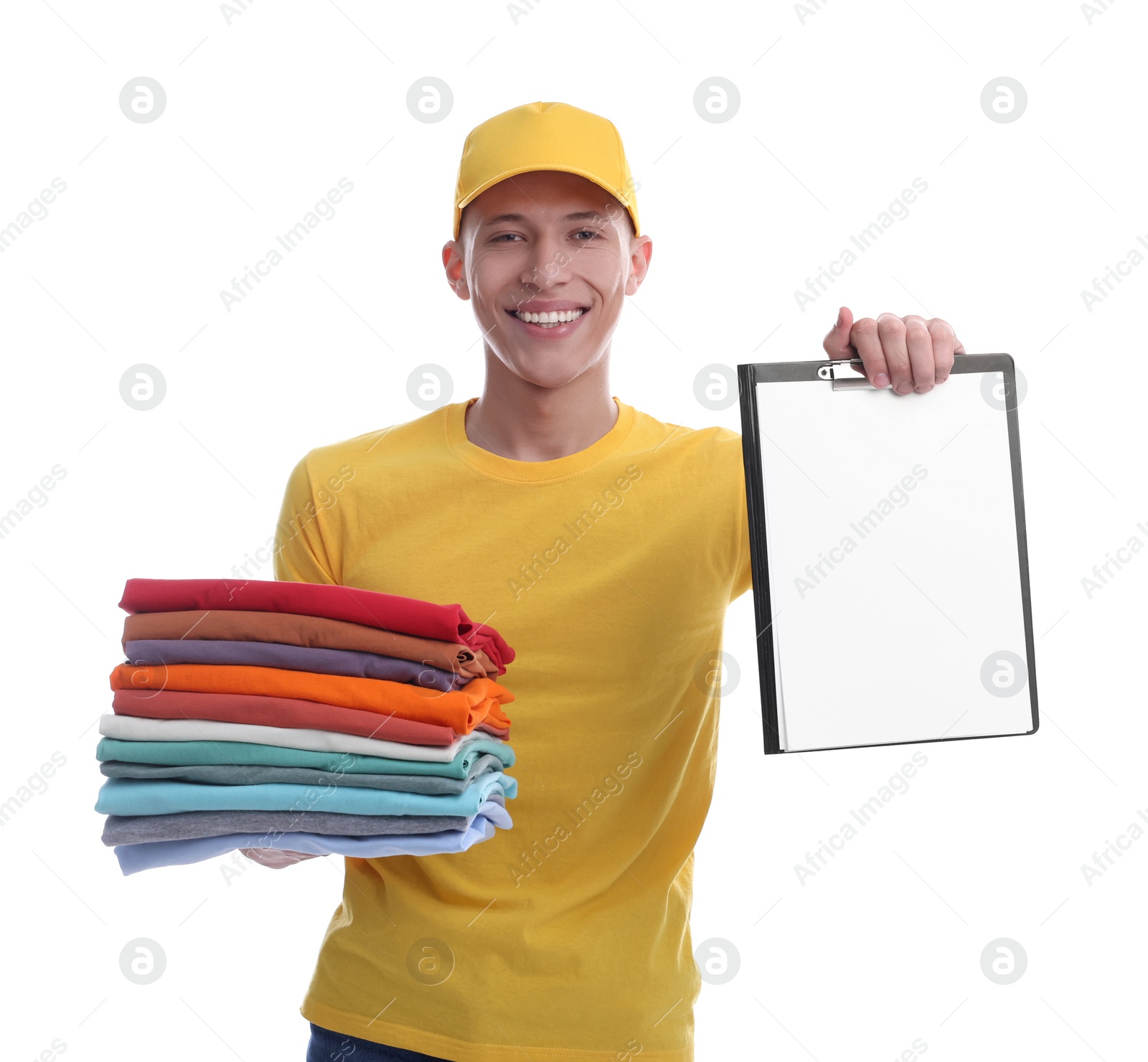 Photo of Dry-cleaning delivery. Happy courier holding folded clothes and clipboard on white background