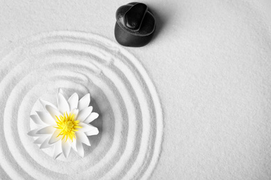Photo of Zen garden. Beautiful lotus flower, stones and space for text on white sand, flat lay