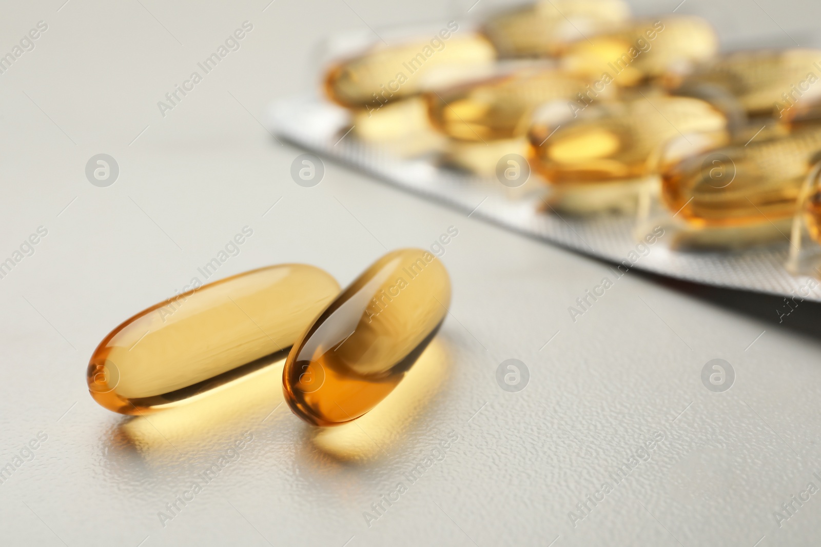 Photo of Dietary supplement capsules on white table, closeup. Space for text