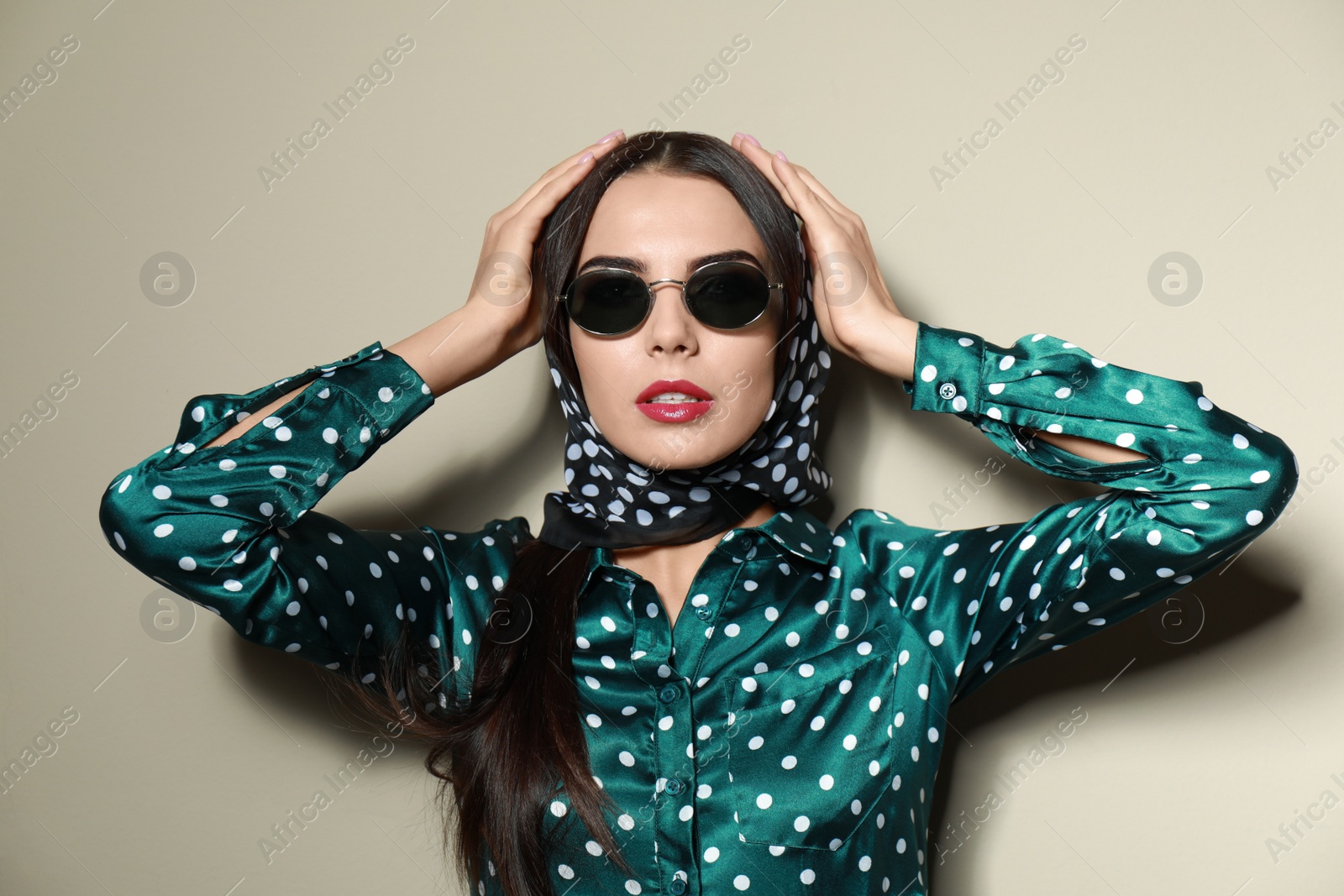 Photo of Beautiful woman in stylish sunglasses on beige background