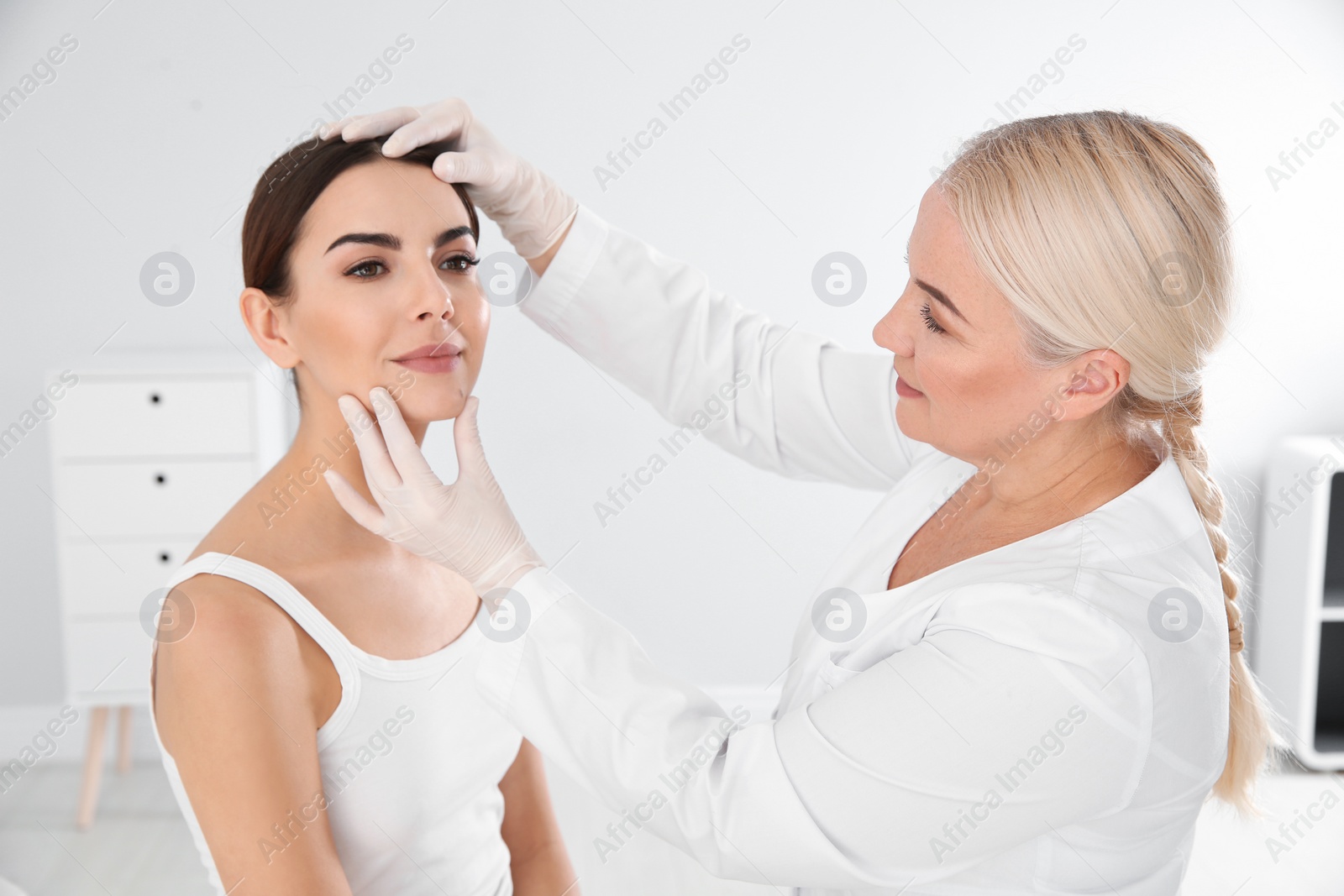 Photo of Dermatologist examining young patient's birthmark in clinic