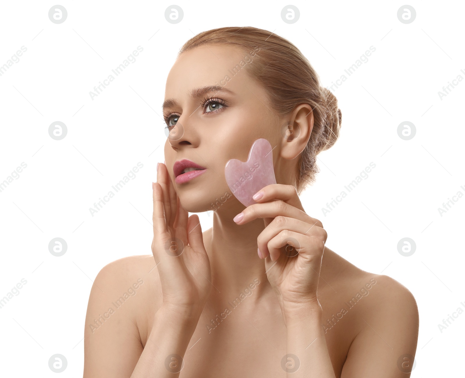 Photo of Beautiful young woman doing facial massage with gua sha tool on white background