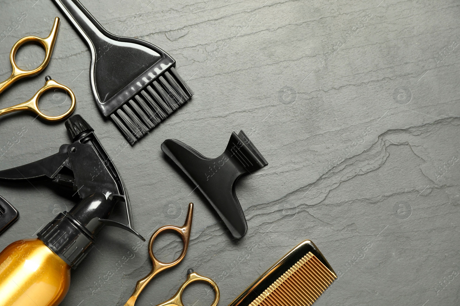 Photo of Hairdressing tools on grey textured background, flat lay. Space for text