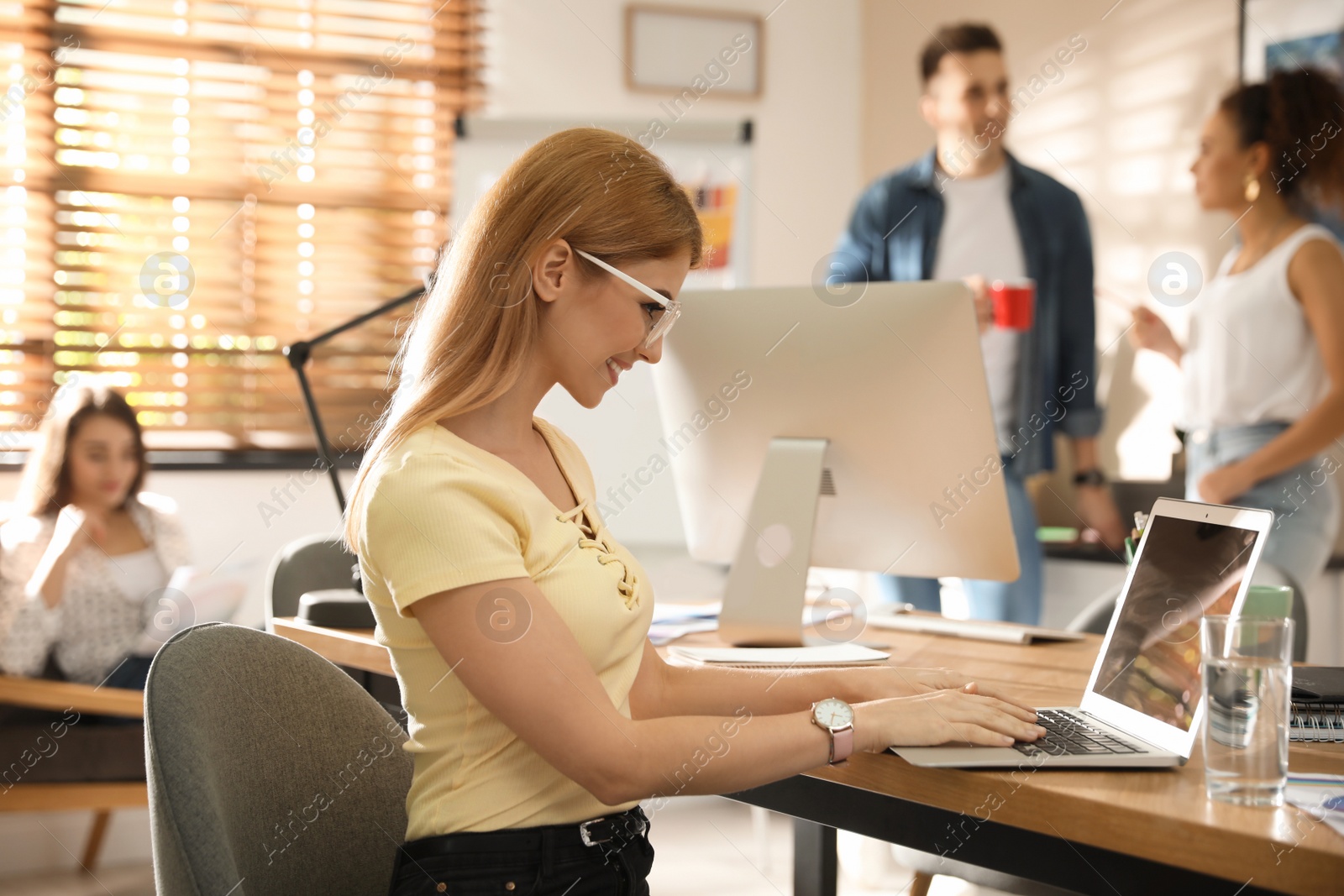 Photo of Female designer working with laptop in office