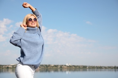 Photo of Happy woman in stylish sweater on beach