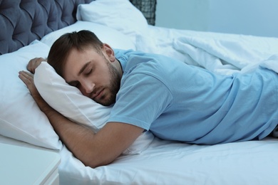 Photo of Young handsome man sleeping in bed at night