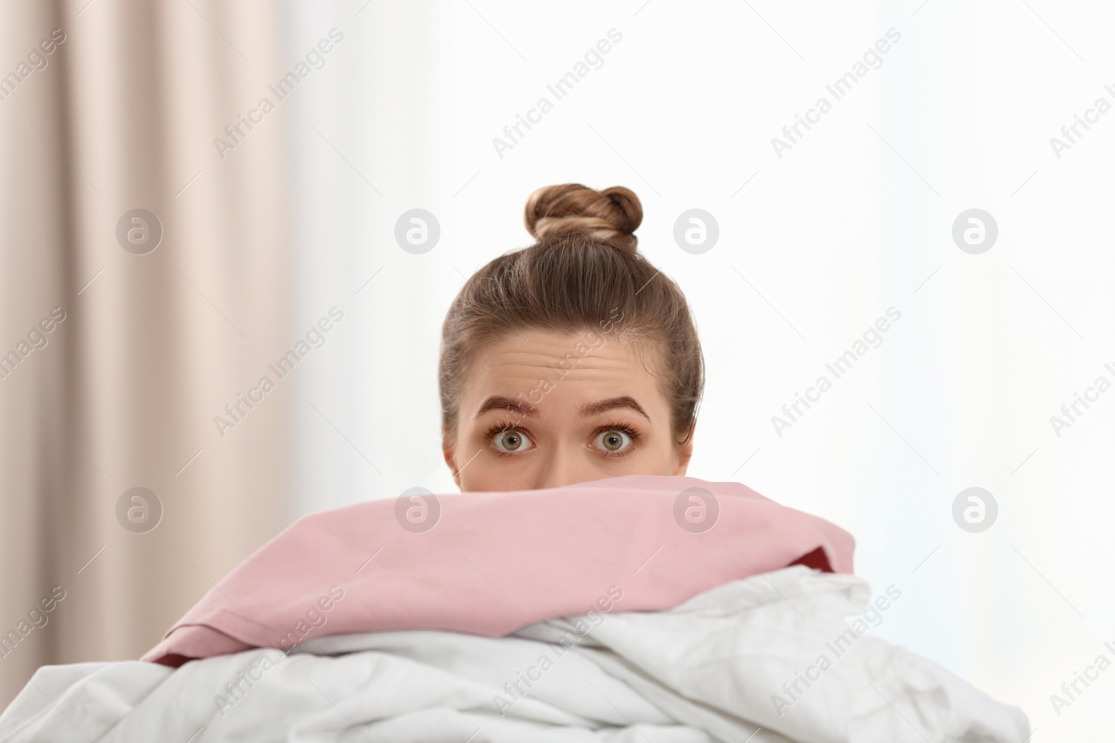 Photo of Woman holding pile of dirty laundry indoors