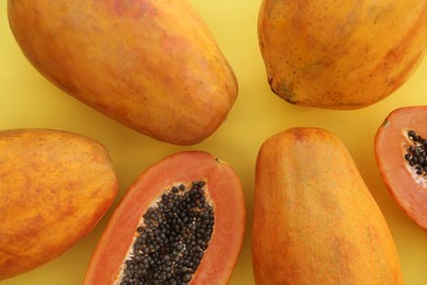 Photo of Fresh ripe cut and whole papaya fruits on light green background, flat lay