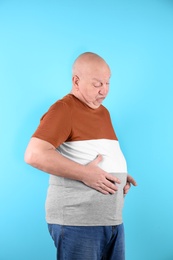 Photo of Fat senior man on color background. Weight loss