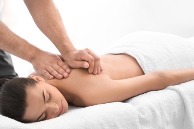 Relaxed woman receiving back massage in wellness center