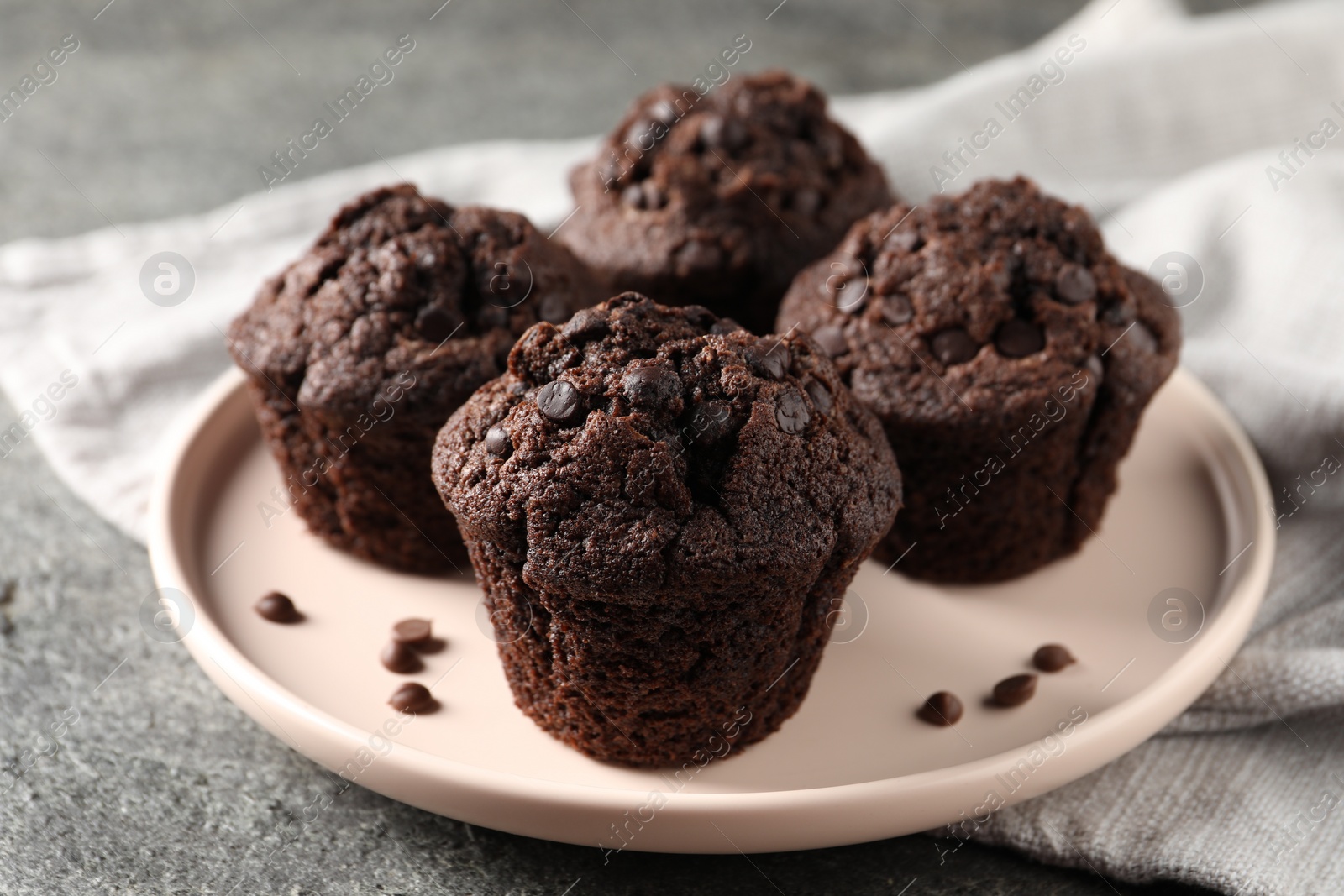 Photo of Delicious fresh chocolate muffins on grey table, closeup