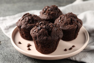 Delicious fresh chocolate muffins on grey table, closeup