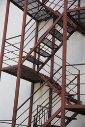 Photo of Metal fire escape ladder near building outdoors, low angle view