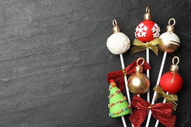 Delicious Christmas themed cake pops on black table, flat lay. Space for text