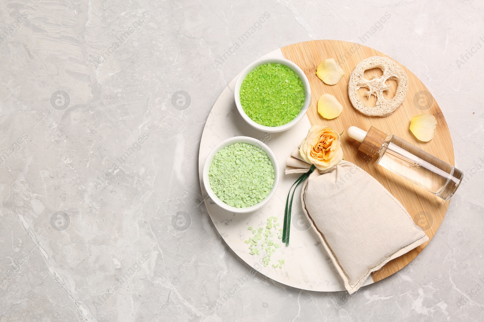 Photo of Bowls with sea salt and different spa products on light grey marble table, flat lay. Space for text