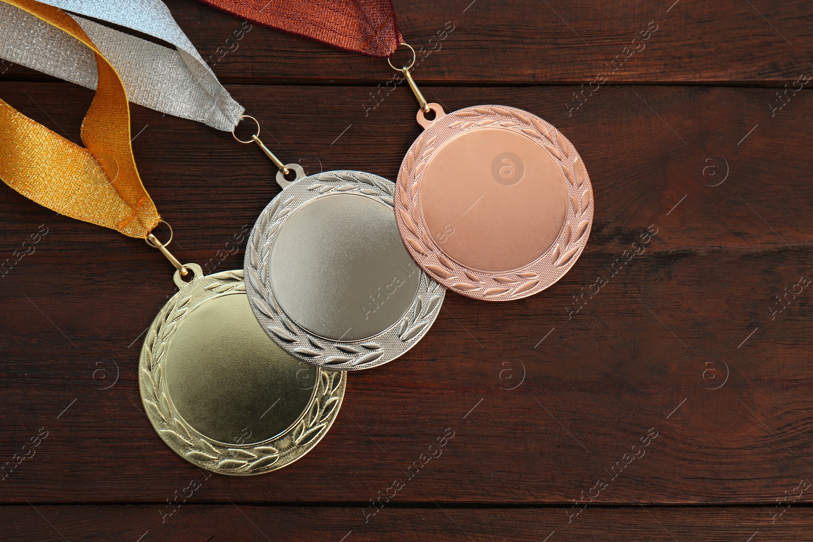 Photo of Gold, silver and bronze medals on wooden background, flat lay. Space for design