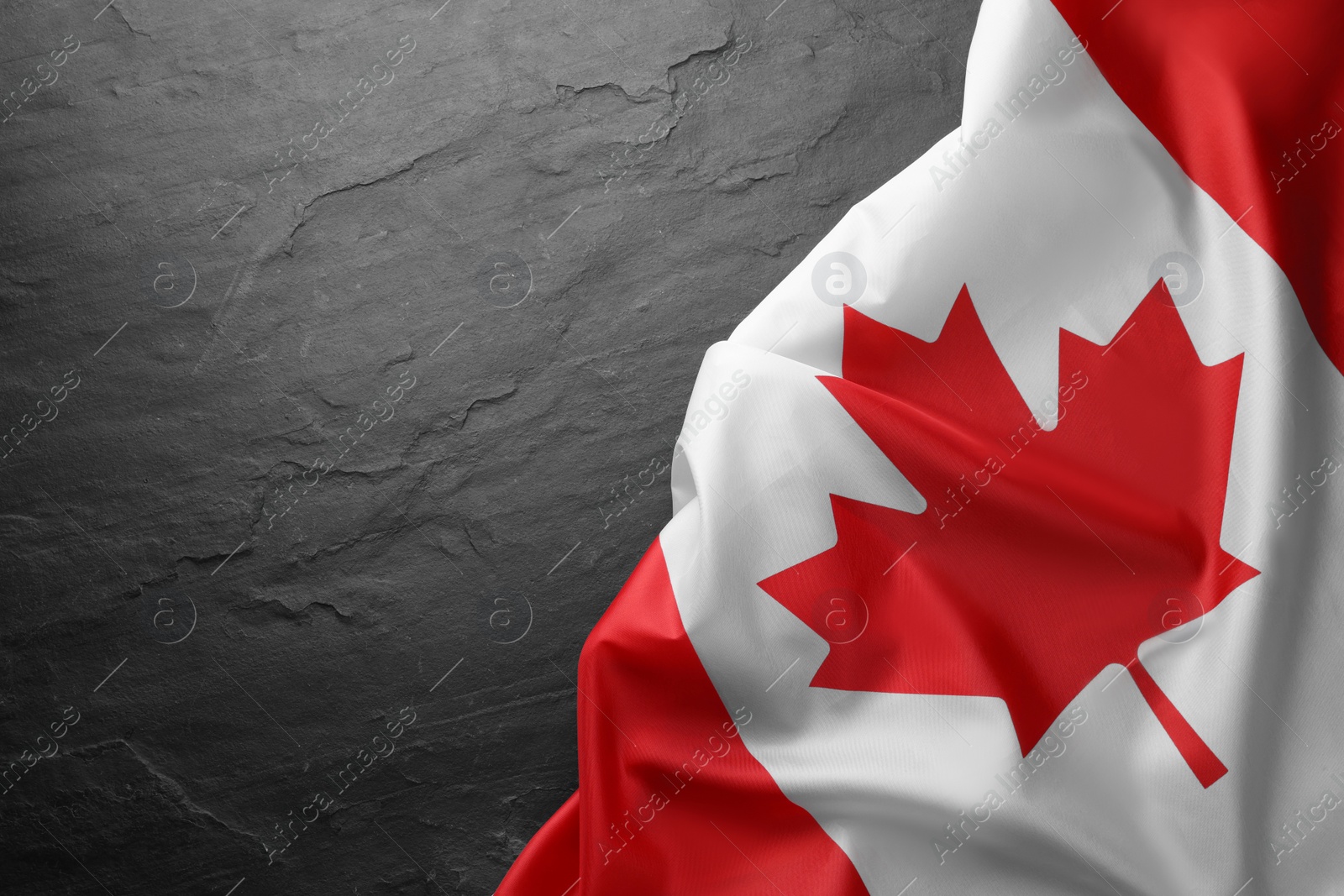 Photo of Flag of Canada on black table, top view. Space for text