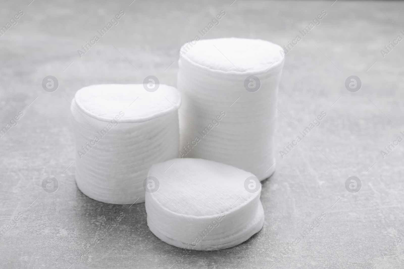 Photo of Stacks of clean cotton pads on light grey table