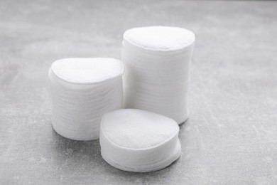 Stacks of clean cotton pads on light grey table